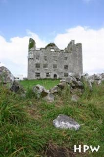 Steine - eine Ruine im Hintergrund - zwischen Bunratty Castle und den Cliffs of Moher