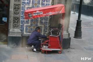 Mexico City, ein Schuhputzer mit seinem Laden an der Straßenecke